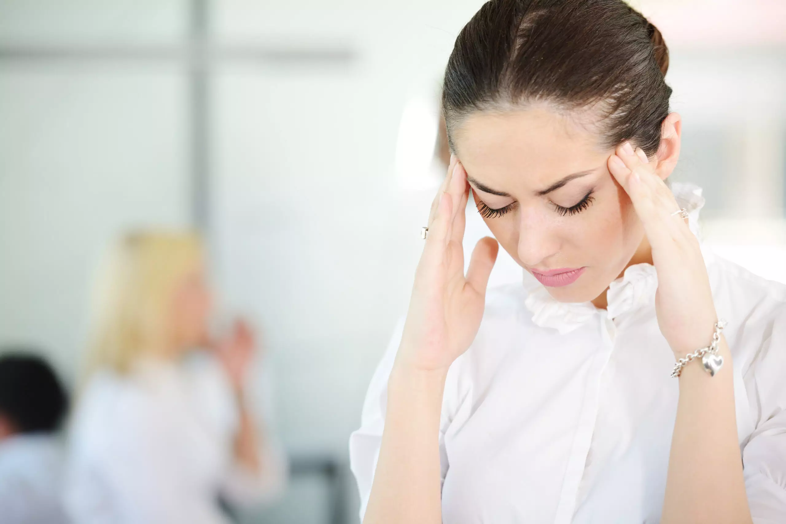 Woman with headache at work.