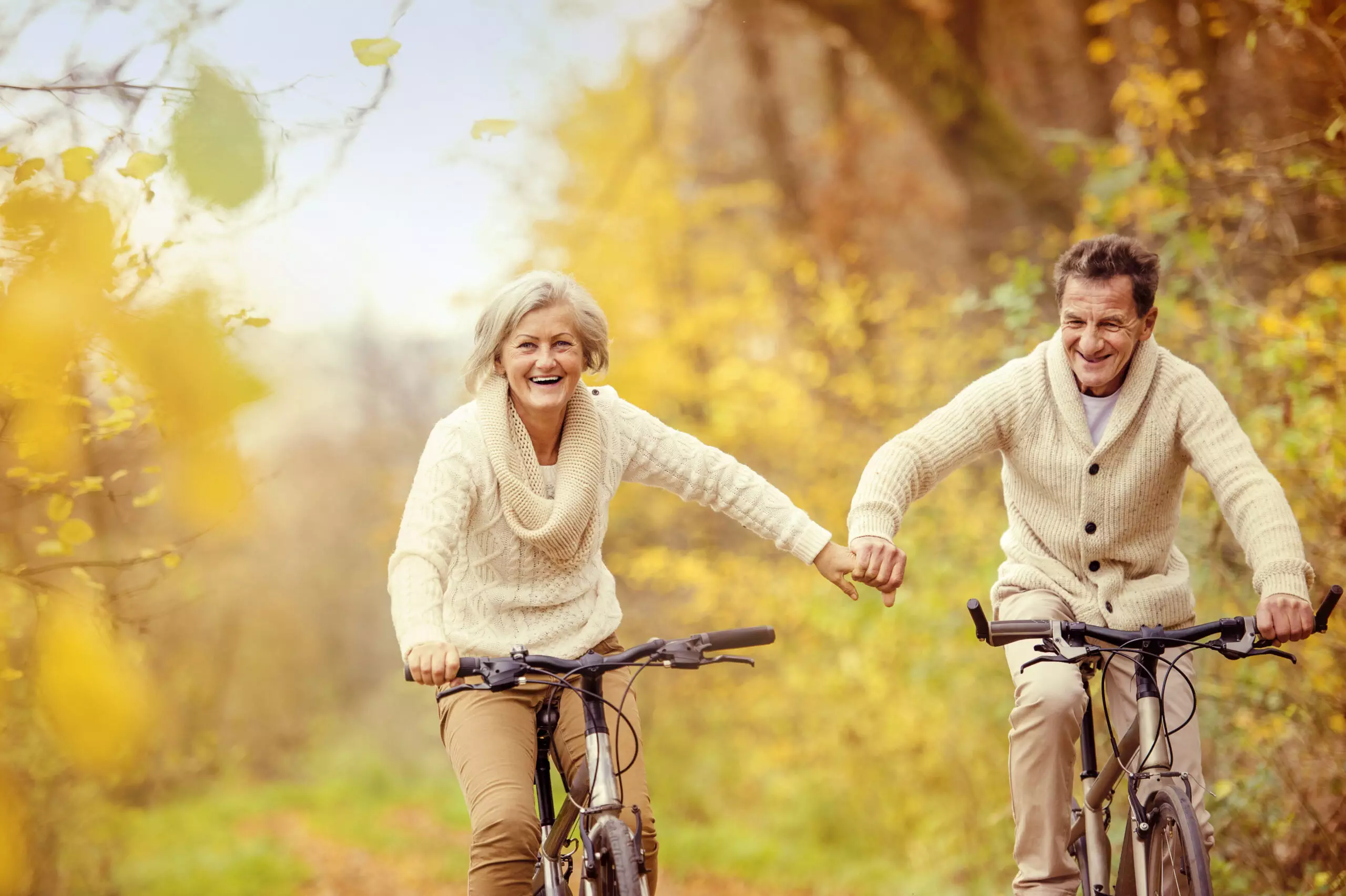 Couple riding bikes in autumn scenery.