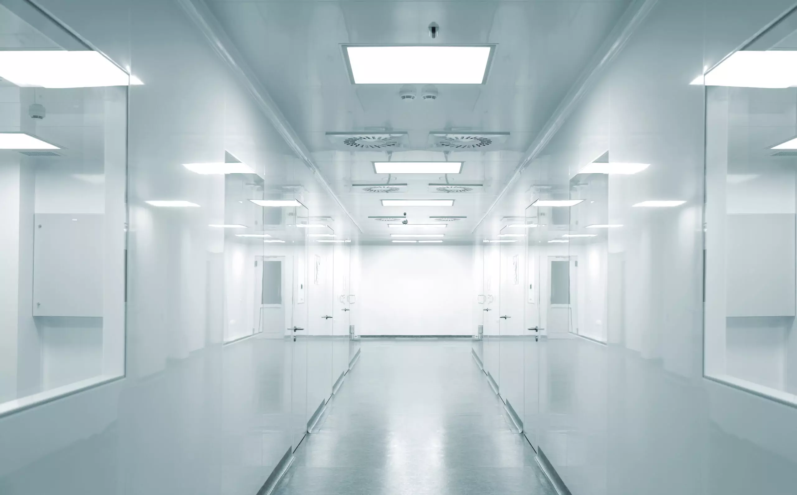Empty modern hospital corridor with fluorescent lighting.