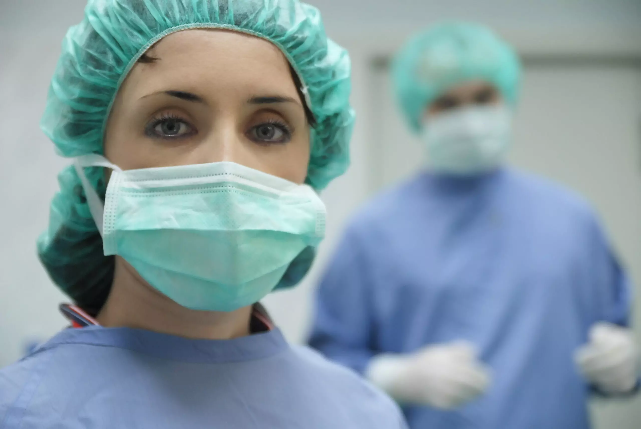 Medical professionals in scrubs and surgical masks.