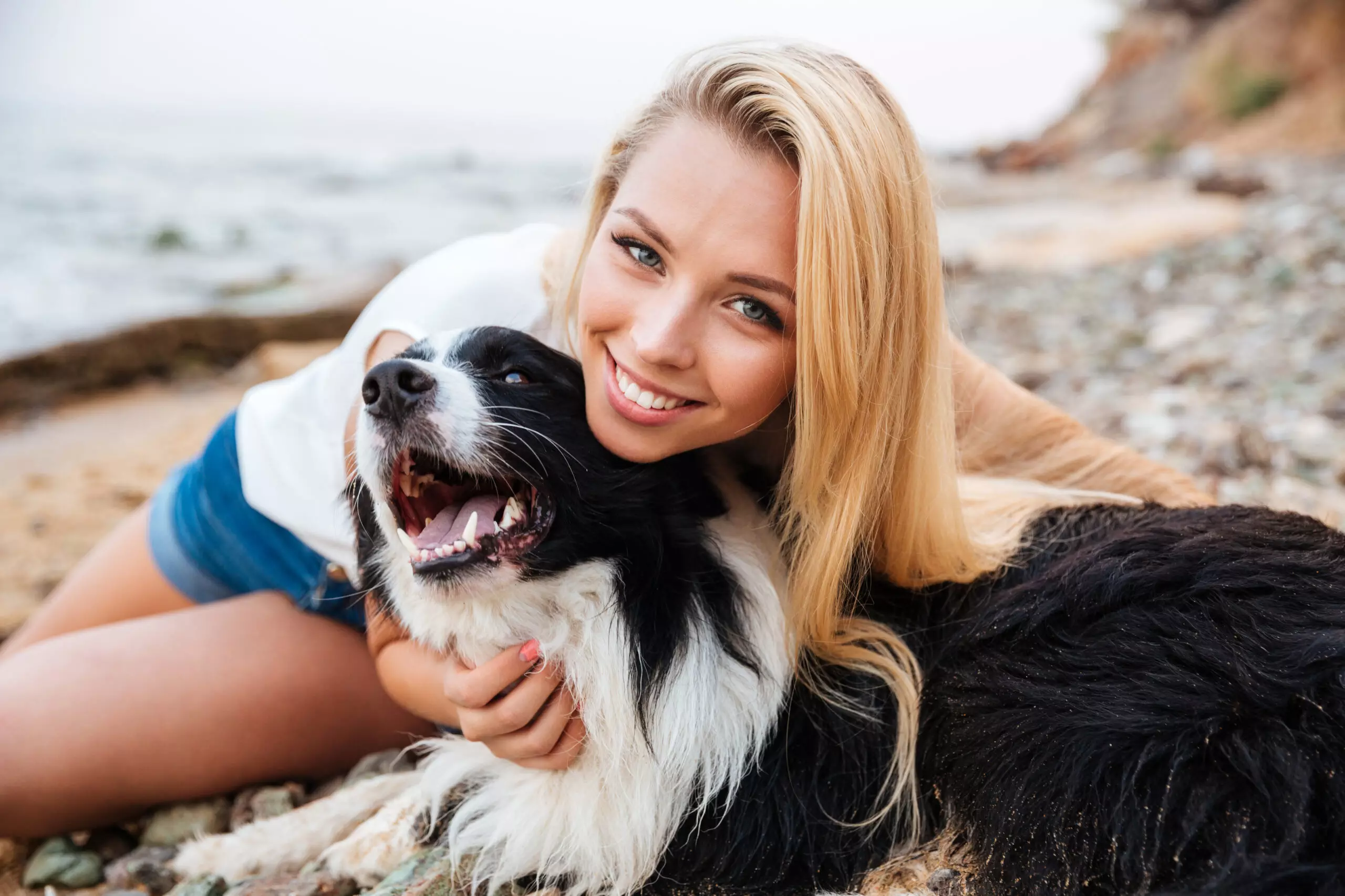 Woman and dog enjoying beach time.